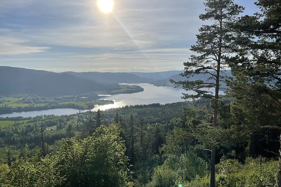 Randsfjorden (nordre ende, northern part of lake), Fluberg kirke, Odnes, Dokkadeltaet, Rostberget, etc. Søndre Land municipality, Norway. Evening sun backlight, forests, hills. View from Granum Gård boarding house 2021-06-01 IMG 1